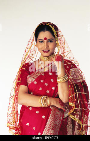 Un ritratto di una lingua bengalese sposa vestito in tradizionale SAREE E GIOIELLI Foto Stock