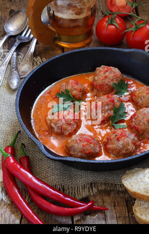 Le polpette di carne in una piastra di ceramica con la birra su di un tavolo di legno Foto Stock