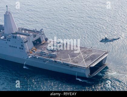 Un Marina indiana UH-3H l'elicottero si avvicina a terra sul ponte di volo dell'U.S. La Marina di San Antonio-classe di trasporto anfibio dock nave USS Anchorage durante gli esercizi di cooperazione con la Marina indiana cacciatorpediniere INS Rajput 26 dicembre 2018 nell'Oceano Indiano. Foto Stock