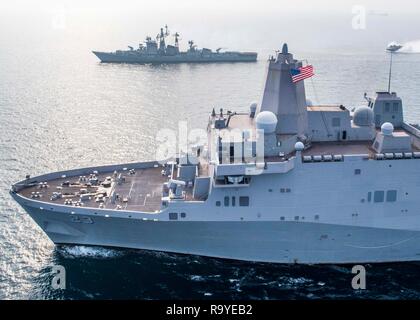 Marina indiana cacciatorpediniere INS Rajput, top, vele al fianco degli Stati Uniti La Marina di San Antonio-classe di trasporto anfibio dock nave USS Anchorage durante gli esercizi di cooperazione con il 26 dicembre 2018 nell'Oceano Indiano. Foto Stock