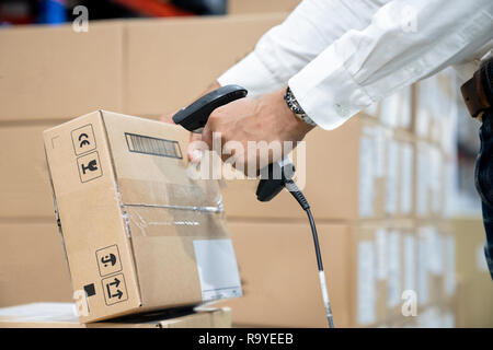 Close up di lavoratore azienda scanner in magazzino - Immagine Foto Stock