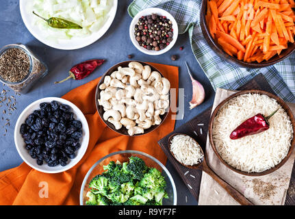 Gli ingredienti di Vegetariano Pulao con noci di acagiù, uvetta, broccoli e spezie su sfondo grunge Foto Stock