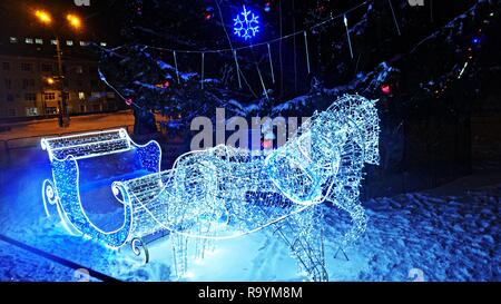 In slitta con i cavalli di luci nei pressi del Nuovo Anno Albero Foto Stock