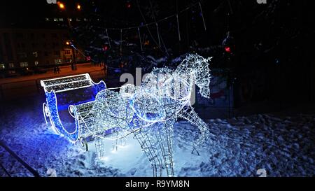 In slitta con i cavalli di luci nei pressi del Nuovo Anno Albero Foto Stock