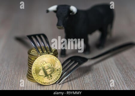 Bitcoin getting nuovo disco forcella cambia, Physical Golden Crytocurrency moneta con forcella e bull accanto ad esso Foto Stock