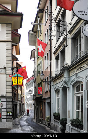 L uomo indossa uniforme rosso soprabito percorrendo a piedi dalla città vecchia street, Furrengasse, Lucerna, Svizzera Foto Stock