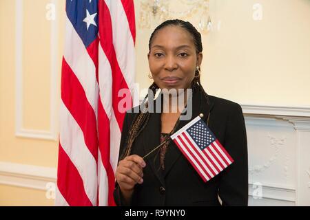 Un recentemente coniate cittadino pone con una bandiera americana a seguito di una immigrazione Cerimonia di naturalizzazione su Bill dei diritti giornata presso gli archivi nazionali, 14 dicembre 2018 a Washington D.C. Foto Stock