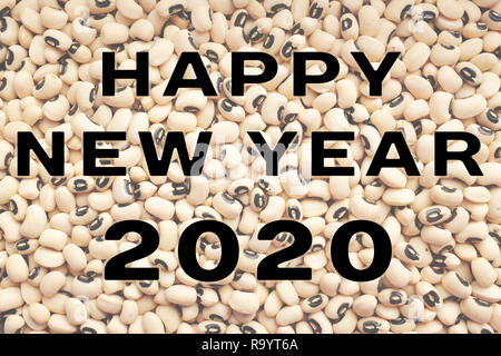 Felice anno nuovo 2020 testo sopra un essiccato black eyed fagioli sfondo, cibo tradizionale considerato per portare prosperità e fortuna Foto Stock