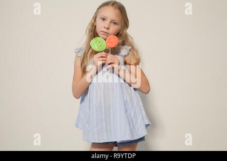 Bambina di mangiare dolciumi dolce lollipop su un bastone Foto Stock