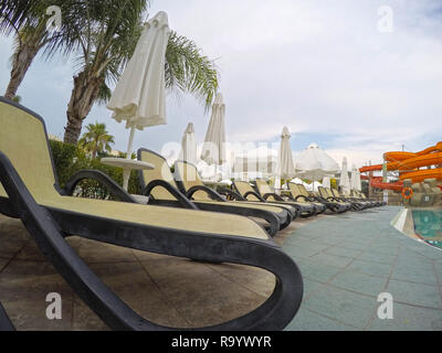 Chaise longue in piscina in un resort mediterraneo Foto Stock