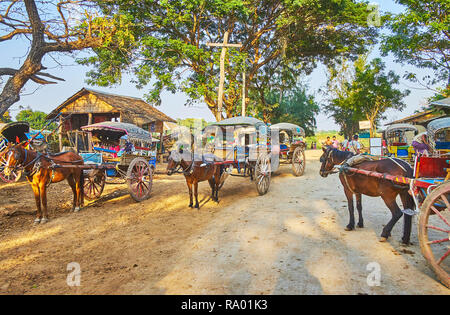 AVA, MYANMAR - Febbraio 21, 2018: loschi strada è occupata con numerosi vintage carrelli A cavalli, aspettando i turisti, il 21 febbraio in Ava. Foto Stock