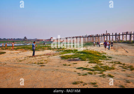 MANDALAY, MYANMAR - Febbraio 21, 2018: turisti attendere il tramonto sopra storica di teak U Bein bridge, attraversando il lago Taungthaman, il 21 febbraio in Ma Foto Stock