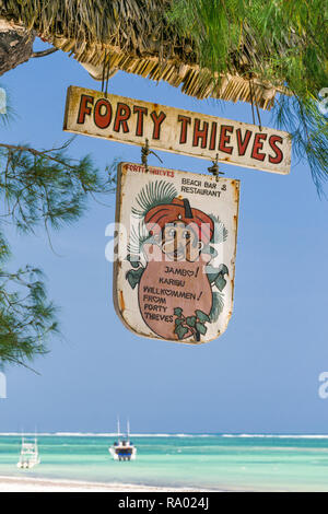 Un segno per il Forty Thieves beach bar e ristorante è appeso a un albero in ombra su un soleggiato blue sky giorno, Diani, Kenya Foto Stock