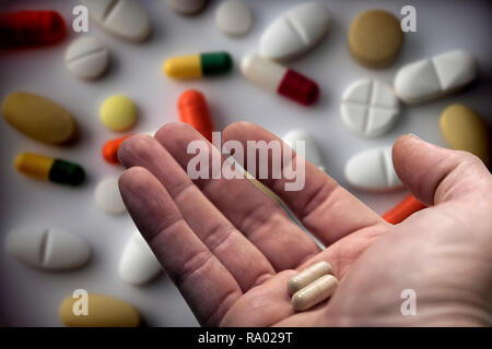 Uomo di mezza età la mano che regge due pillole, assunzione di farmaco quotidiano Foto Stock