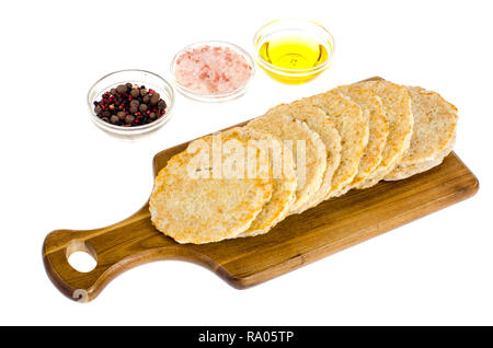 Congelati materie frittelle di patate sul tagliere per la cottura. Foto Studio Foto Stock