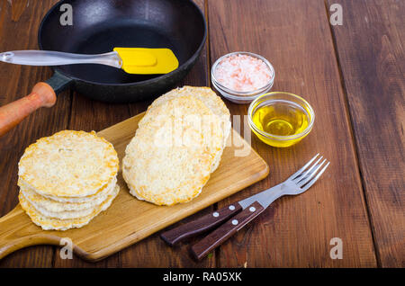 Congelati materie frittelle di patate sul tagliere per la cottura. Foto Studio Foto Stock