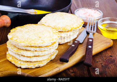 Congelati materie frittelle di patate sul tagliere per la cottura. Foto Studio Foto Stock