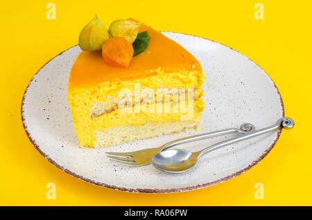 Pezzo di torta di mousse luminoso su sfondo giallo. Foto Studio Foto Stock