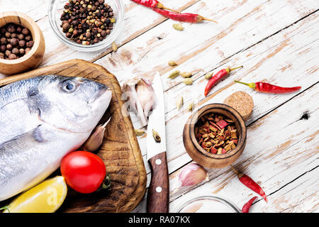 Non cotte fresche dorado o Orate di mare Pesce con erbe e spezie sulla scheda di cottura Foto Stock