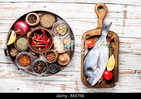 Crudo fresco pesce dorado con ingredienti per la cottura Foto Stock