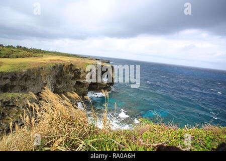 Manzamou con cielo cupo. Una barriera corallina cliff contro cui onde furiose crash, punto di riferimento di Okinawa Foto Stock