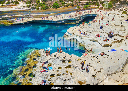 MARSAXLOKK, Malta - 18 giugno 2018: i vacanzieri godere il loro tempo sulla spiaggia di San Pietro piscina, uno dei luoghi più belli di Delimara Foto Stock