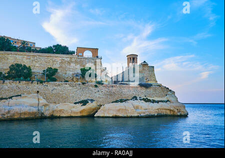 L'enorme parete di St Christopher Bastion con Rotunda (cappella) dell assedio Bell Memoriale di guerra sulla sommità del counterguard, Valletta, Malta. Foto Stock