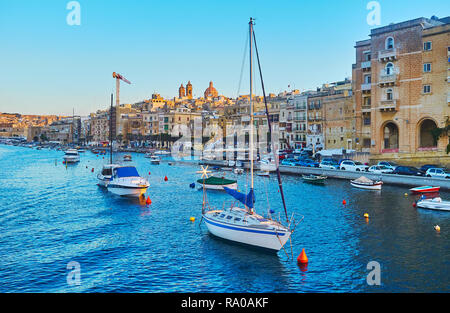 Il piacevole viaggio intorno alla città medievale di La Valletta Grand Harbour, numerose barche da pesca e luzzu sono ormeggiati a riva di L-Isla, Senglea, Malta Foto Stock