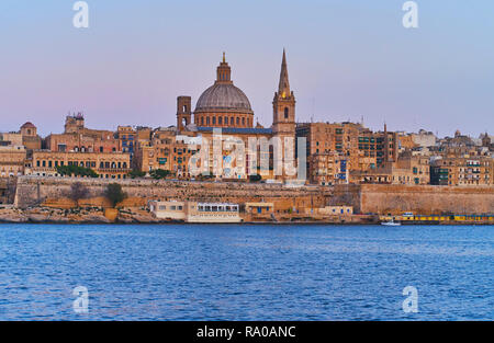 Godetevi il tramonto yacht viaggio lungo la Valletta nord del porto con una vista su San Paolo Pro-Cathedral anglicana e cupola della chiesa carmelitana tra la med Foto Stock