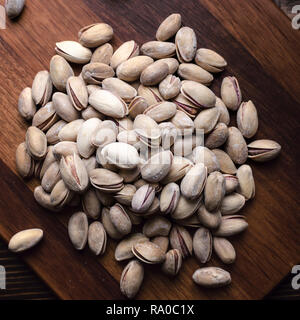 Deliziosi pistacchi salati su sfondo di legno dal di sopra Foto Stock