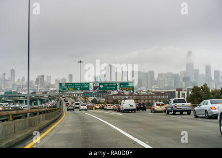 Dicembre 23, 2018 San Francisco / CA / STATI UNITI D'AMERICA - guida in autostrada verso il centro cittadino di San Francisco in un giorno nuvoloso; il distretto finanziario skyline di Foto Stock