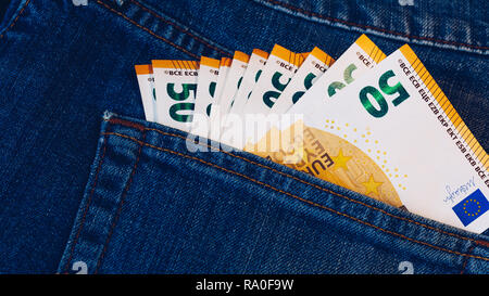 Le fatture in euro in tasca dei jeans sfondo. Le banconote in euro in jeans tasca posteriore. Concetto di gente ricca, salvataggio o spendere soldi. Euro Bills cadano fuori. Foto Stock