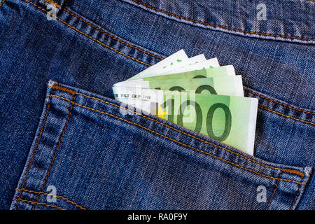 Le fatture in euro in tasca dei jeans sfondo. Le banconote in euro in jeans tasca posteriore. Concetto di gente ricca, salvataggio o spendere soldi. Euro Bills cadano fuori. Foto Stock