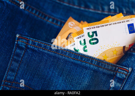 Le fatture in euro in tasca dei jeans sfondo. Le banconote in euro in jeans tasca posteriore. Concetto di gente ricca, salvataggio o spendere soldi. Euro Bills cadano fuori. Foto Stock