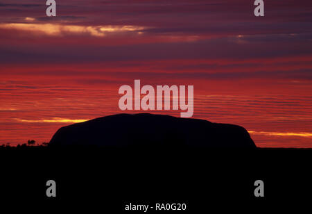 Uluru Ayers Rock nel cuore del territorio del nord del centro rosso deserto è considerato uno dell'Australia che le principali attrazioni turistiche. Foto Stock