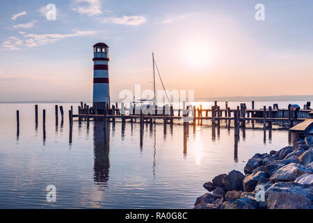 Faro di lago di Neusiedl, Podersdorf am See, Burgenland, Austria. Faro al tramonto in Austria. Il molo di legno con il faro in Podersdorf sul lak Foto Stock