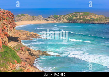 Antenna vista oceano dalla cima delle scogliere di Robberg Riserva Naturale, Plettenberg Bay, Sud Africa. Spiaggia, le onde e la colonia di foche all'orizzonte. Foto Stock