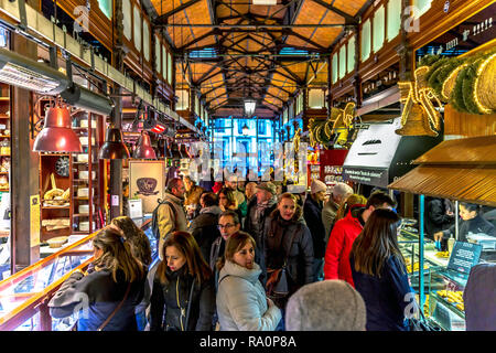 Madrid, Spagna - 4 Dic 2017 - un grande gruppo di persone all'interno del mercato comunale di Madrid con un sacco di piccoli store intorno ad esso in Spagna Foto Stock