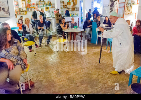 05-03-15, Marrakech, Marocco. Un uomo anziano racconta storie per un pubblico di turisti presso il Cafe orologio racconto di sera. Foto: © Simon Grosset Foto Stock