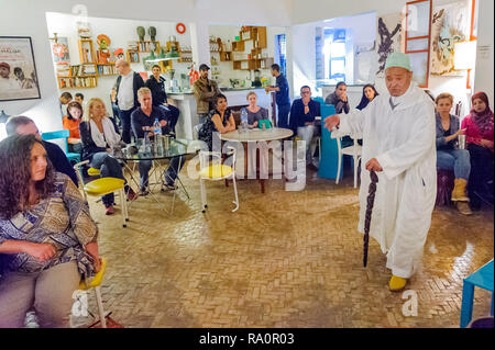 05-03-15, Marrakech, Marocco. Un uomo anziano racconta storie per un pubblico di turisti presso il Cafe orologio racconto di sera. Foto: © Simon Grosset Foto Stock
