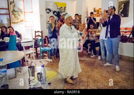 05-03-15, Marrakech, Marocco. Un uomo anziano racconta storie per un pubblico di turisti presso il Cafe orologio racconto di sera. Foto: © Simon Grosset Foto Stock