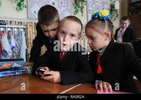 Gli scolari ucraino giocando con il mobile.La scuola di Radinka è situato nei pressi di Chernobyl Zona di esclusione.La zona è contaminata. Foto Stock