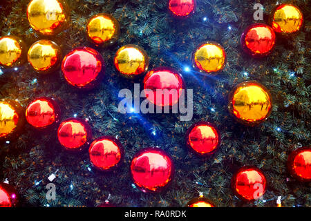 Luminose e chiny rosso e oro baubles di natale su una pelliccia di pino albero di natale Foto Stock