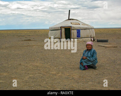 Mongolo vecchia donna seduta di fronte yurt in aperta campagna di steppa, Bulgan, Mongolia Foto Stock