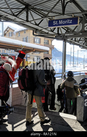 Passngers e gli sciatori che arrivano a San Moritz rail station in Svizzera Foto Stock