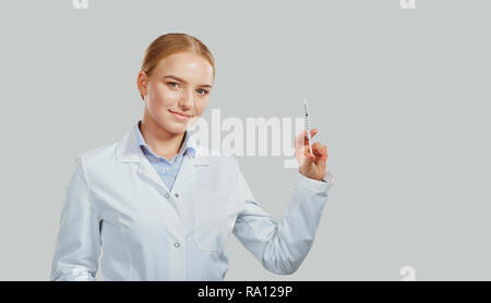Donna medico con una siringa in mano sul background. Foto Stock