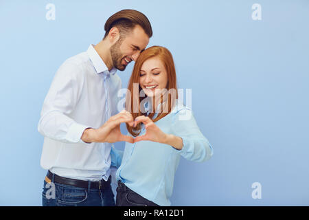 Matura in amore con un cuore su sfondo blu. Foto Stock