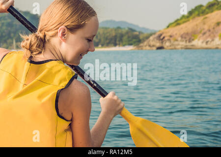Sorridente giovane donna kayak sul mare. Felice giovane donna canoa in mare su un giorno di estate Foto Stock