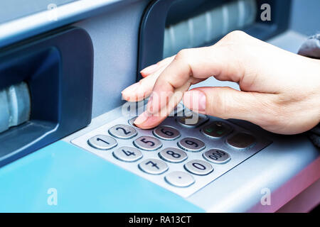 Close-up della donna s mano introducendo codice pin al bancomat per il prelievo di contanti Foto Stock