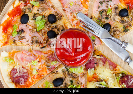 Sei fette di pizza con diversi condimenti sulla tavola di legno. Foto Studio Foto Stock